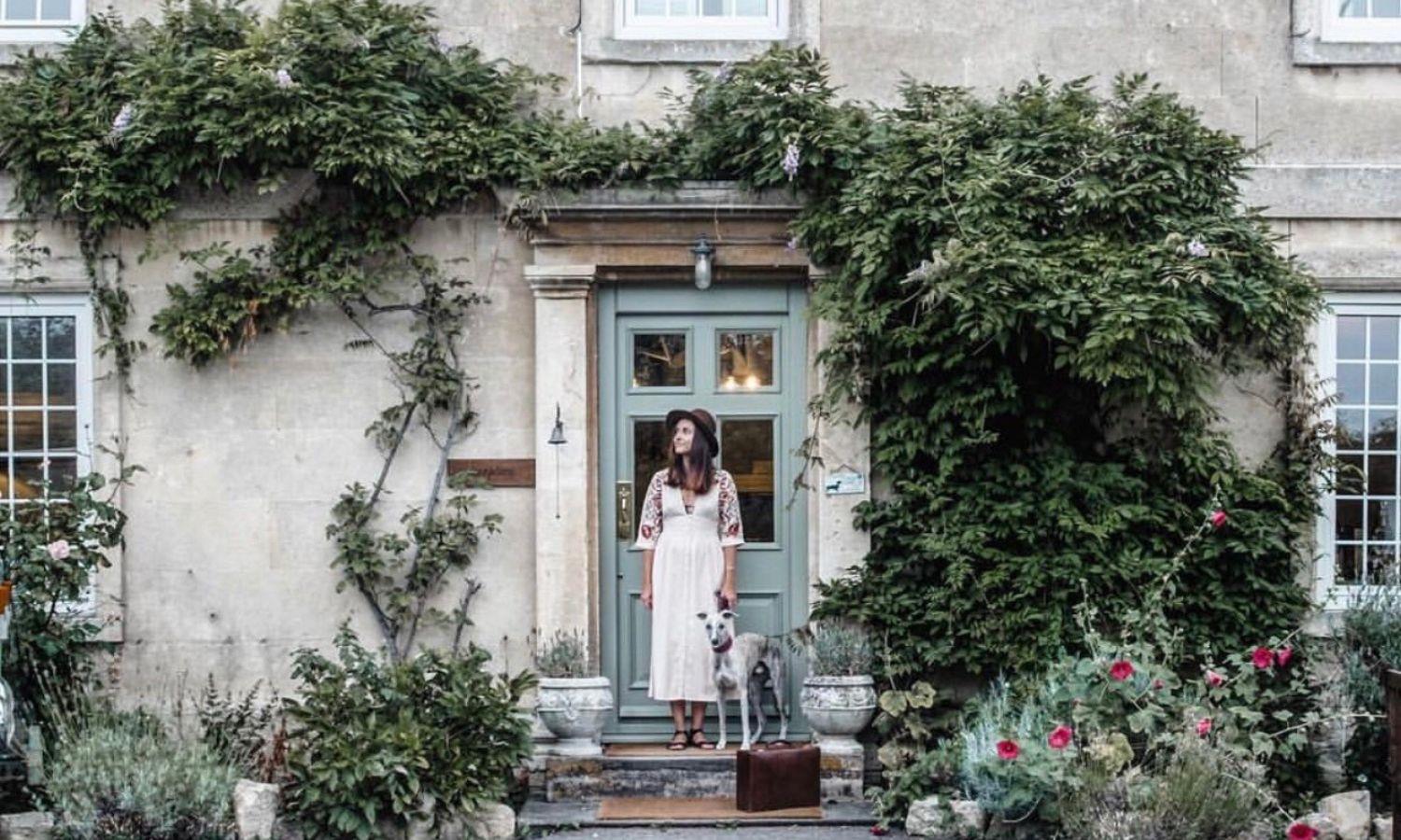 Woman and her dog stood on the doorstep of Georgian farmhouse hotel