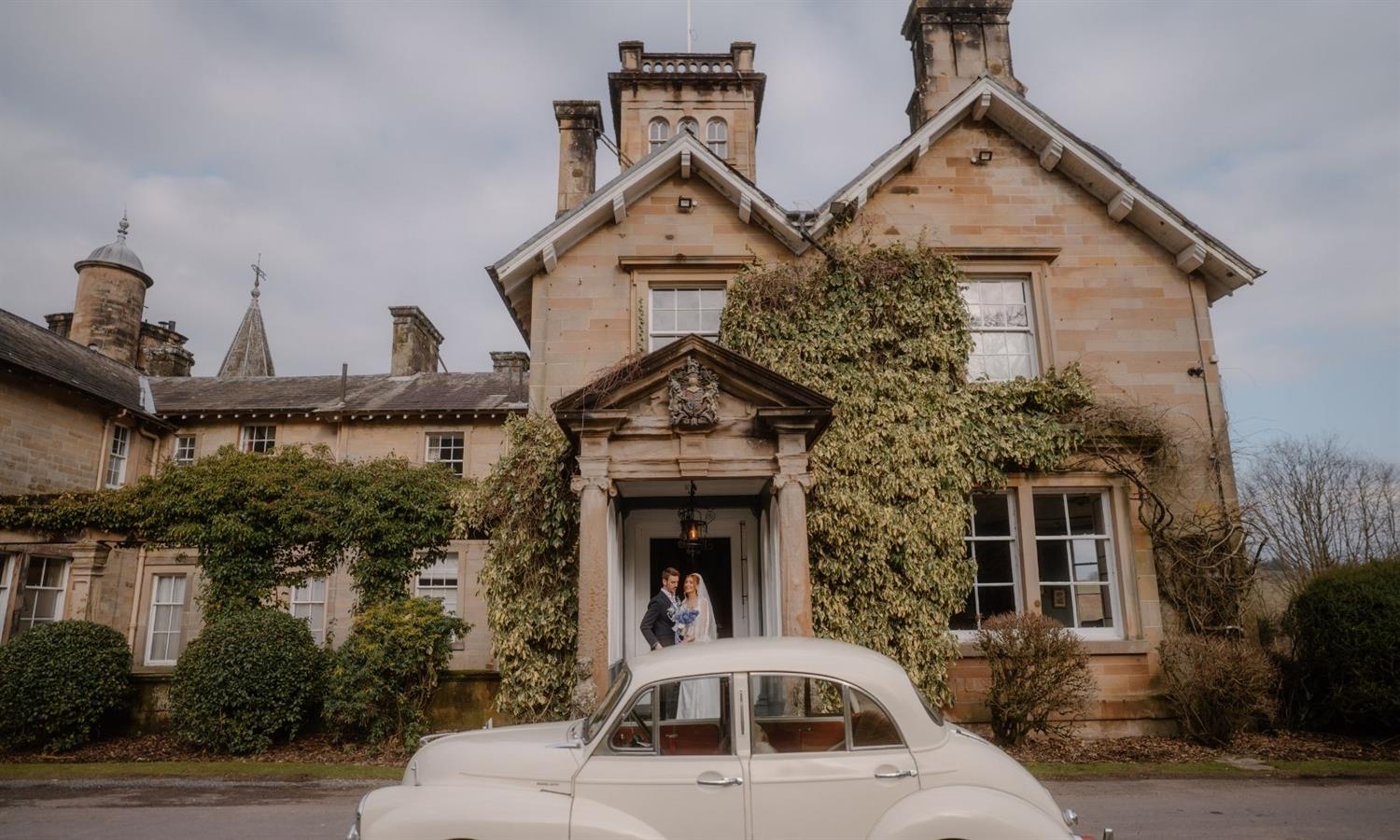 Wedding couple and vintage wedding car outside Auchen Castle