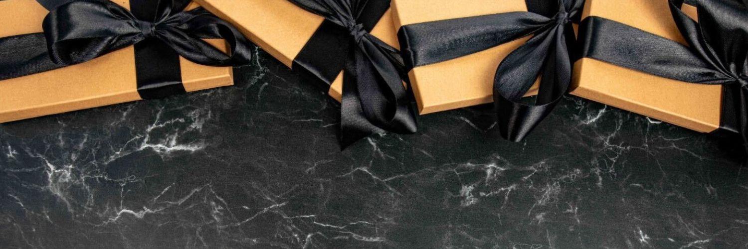 Gifts wrapped in black ribbons on black marble table