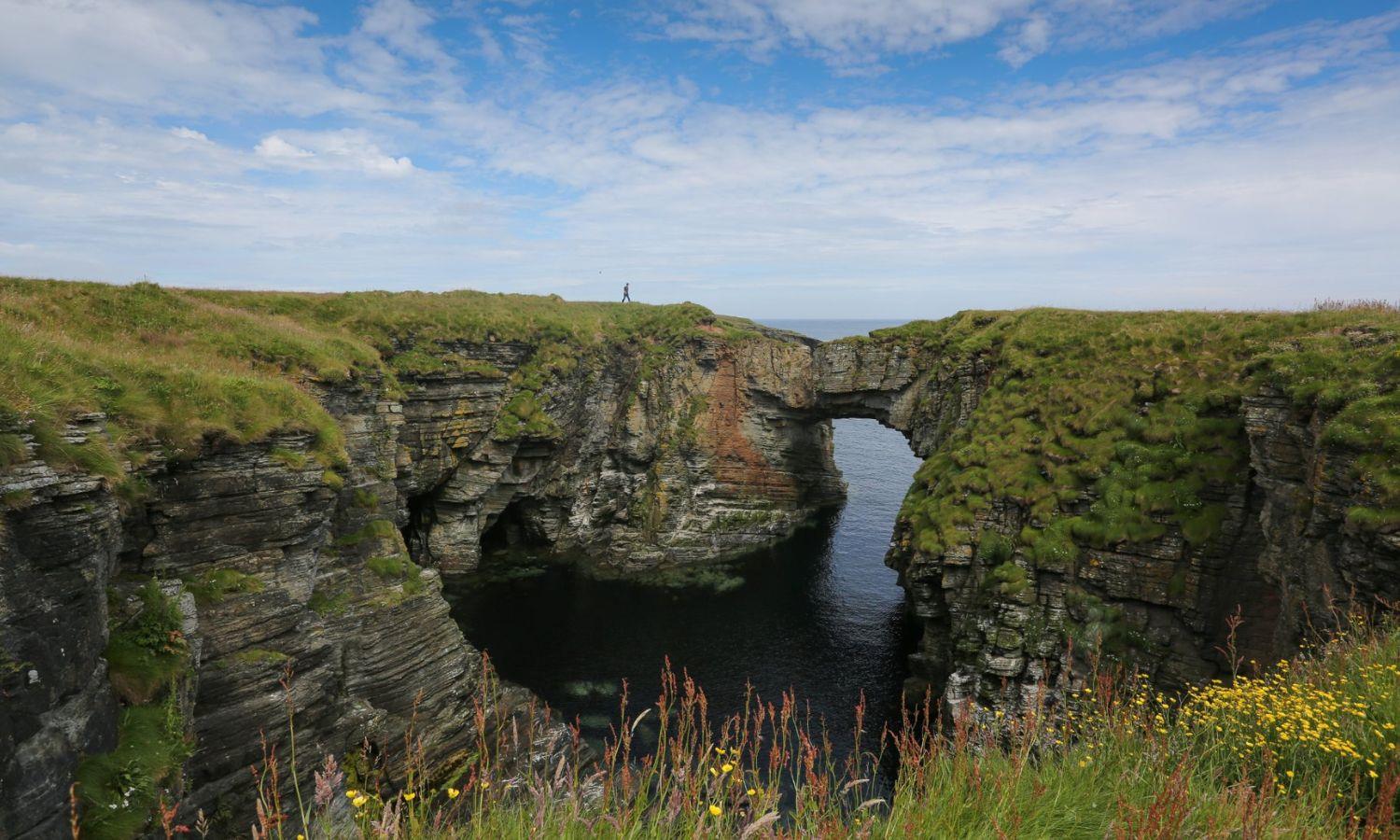 Grassy cliffs and sea arch on Orkney 