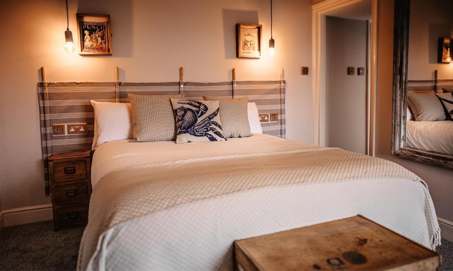 Deluxe Sea View Bedroom at The Ship Inn with bed, cushions and windbreaker headboard