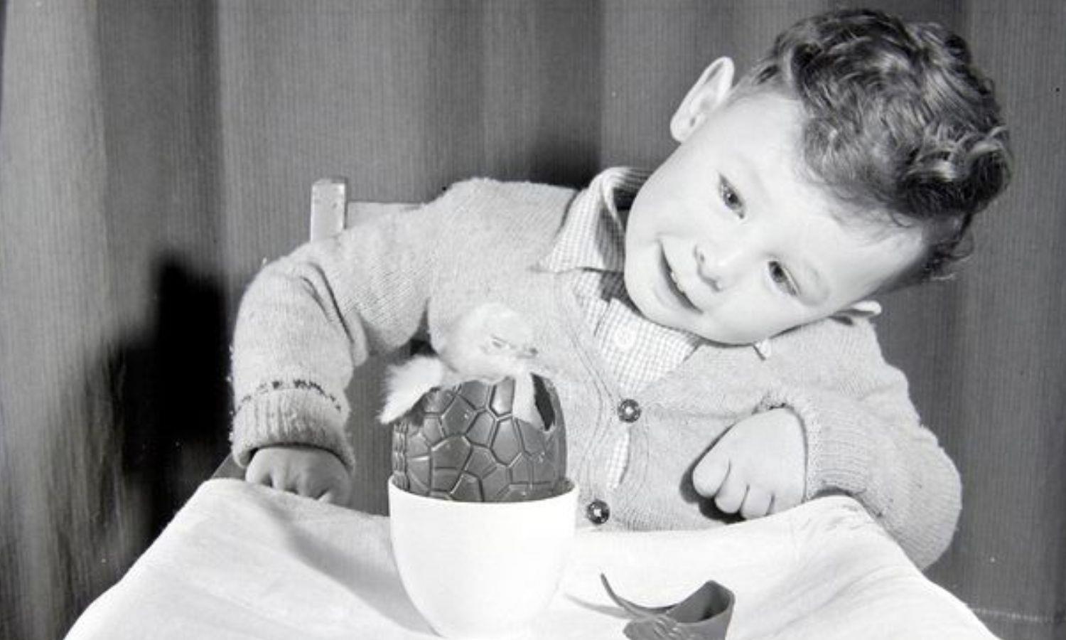 Child looking at live chick in a chocolate egg