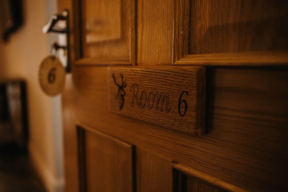 Open wooden door with key in lock