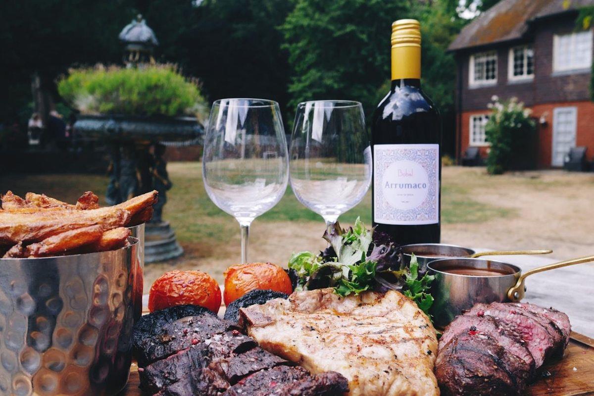 Wine and steak dinner with chips and sauces