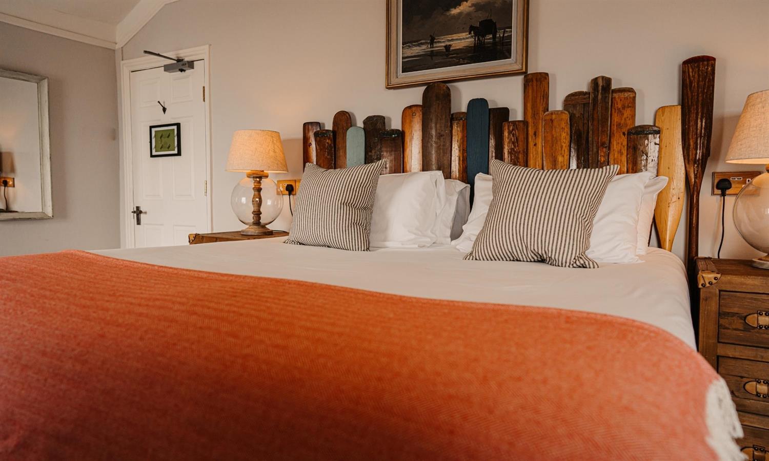 Deluxe Sea View Bedroom at The Ship Inn with bed, cushions and paddle headboard