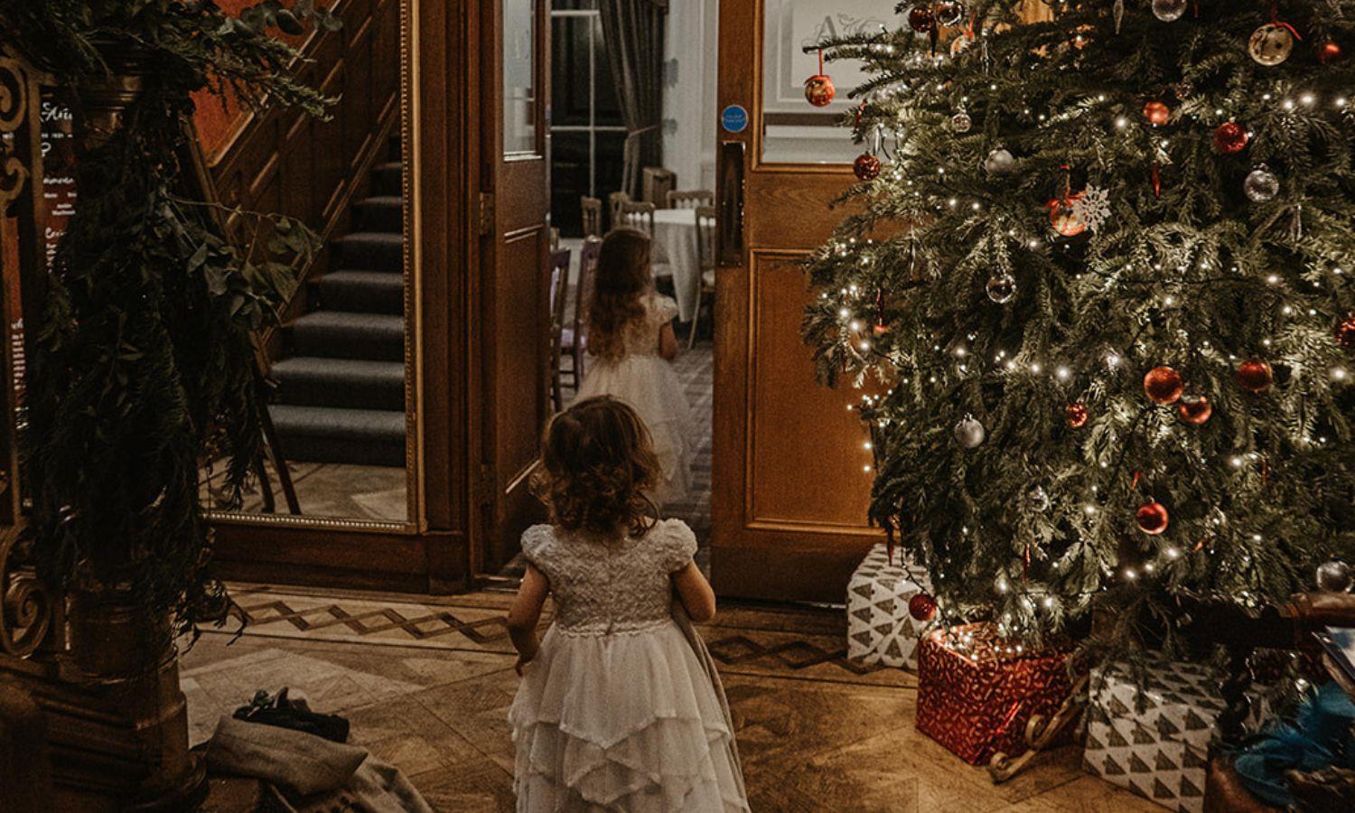 Children walking through hallway filled with Christmas decorations