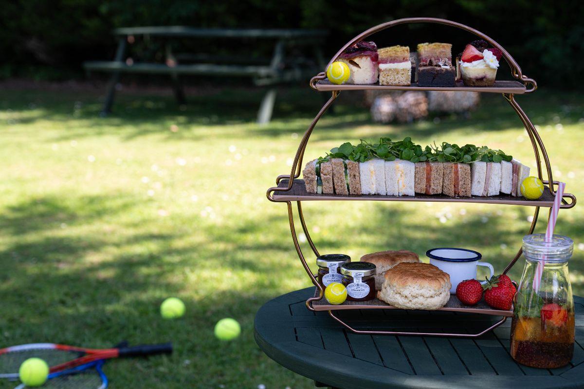 Afternoon tea with tennis racket and tennis balls in background