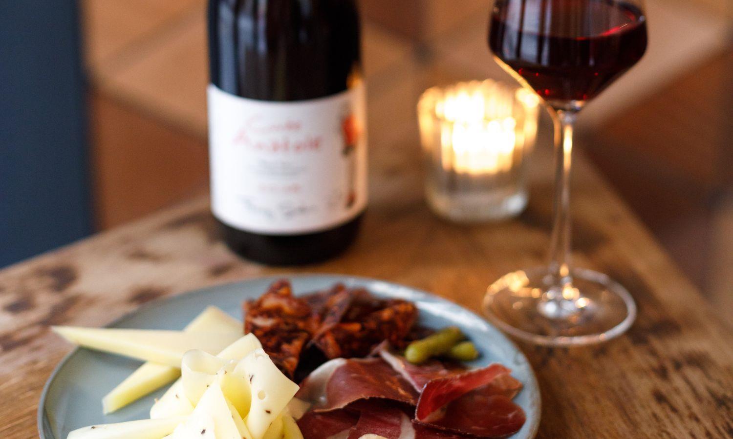 Cheese and meat plate with glass of red wine