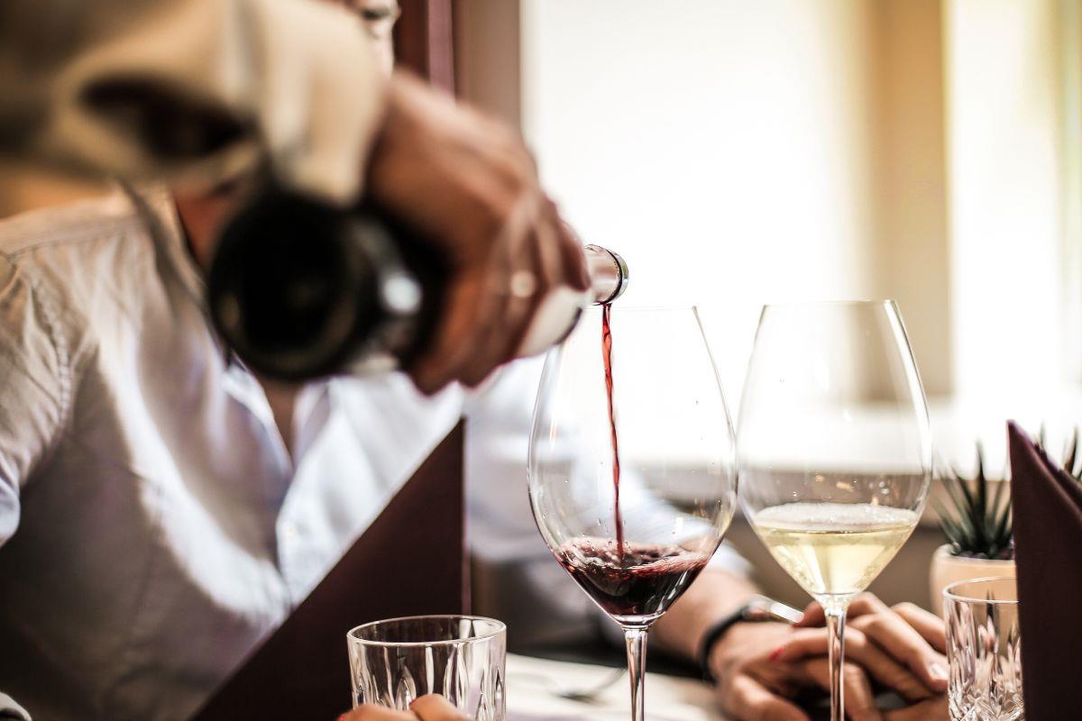 Waiter pouring red wine into a wine glass