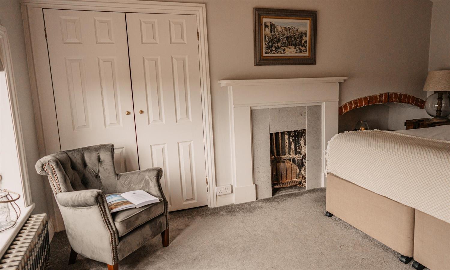 Premium Double Bedroom at Ship Inn with chair and fireplace