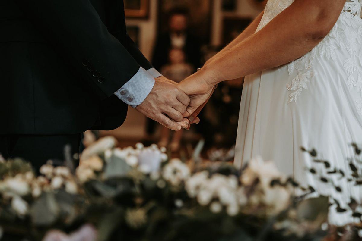 Couple holding hands at wedding ceremony