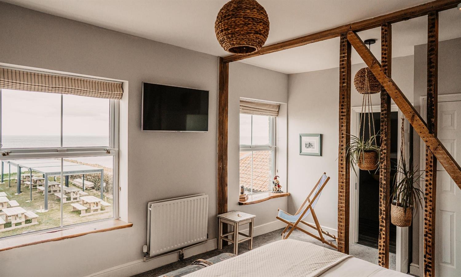 Deluxe Sea View Bedroom at The Ship Inn with sea view, deckchair and plants