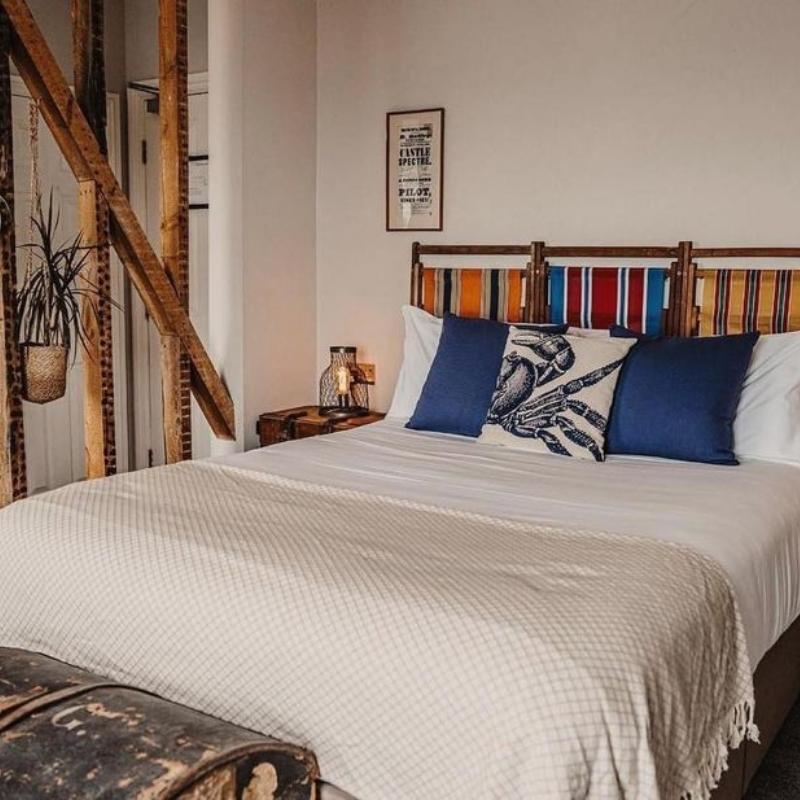 Bed at The Ship Inn with cushions and deckchair headboard