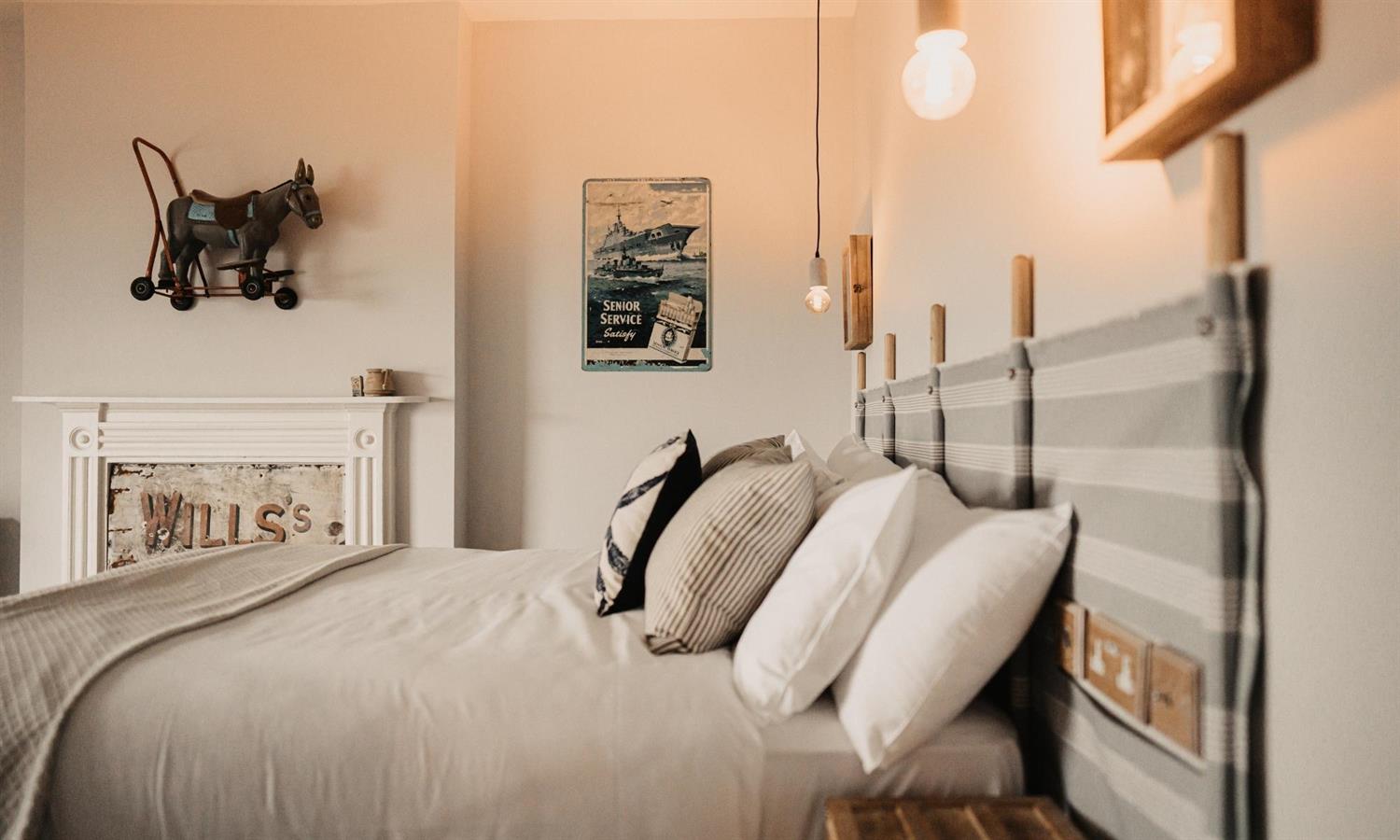 Deluxe Sea View Bedroom at The Ship Inn with bed, cushions and windbreaker headboard