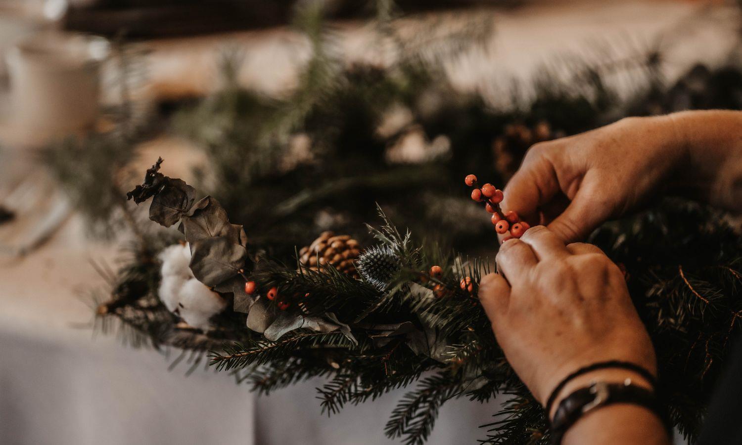 Adding finishing touches to a Christmas wreath