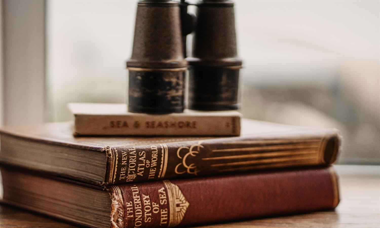 Binoculars on pile of books