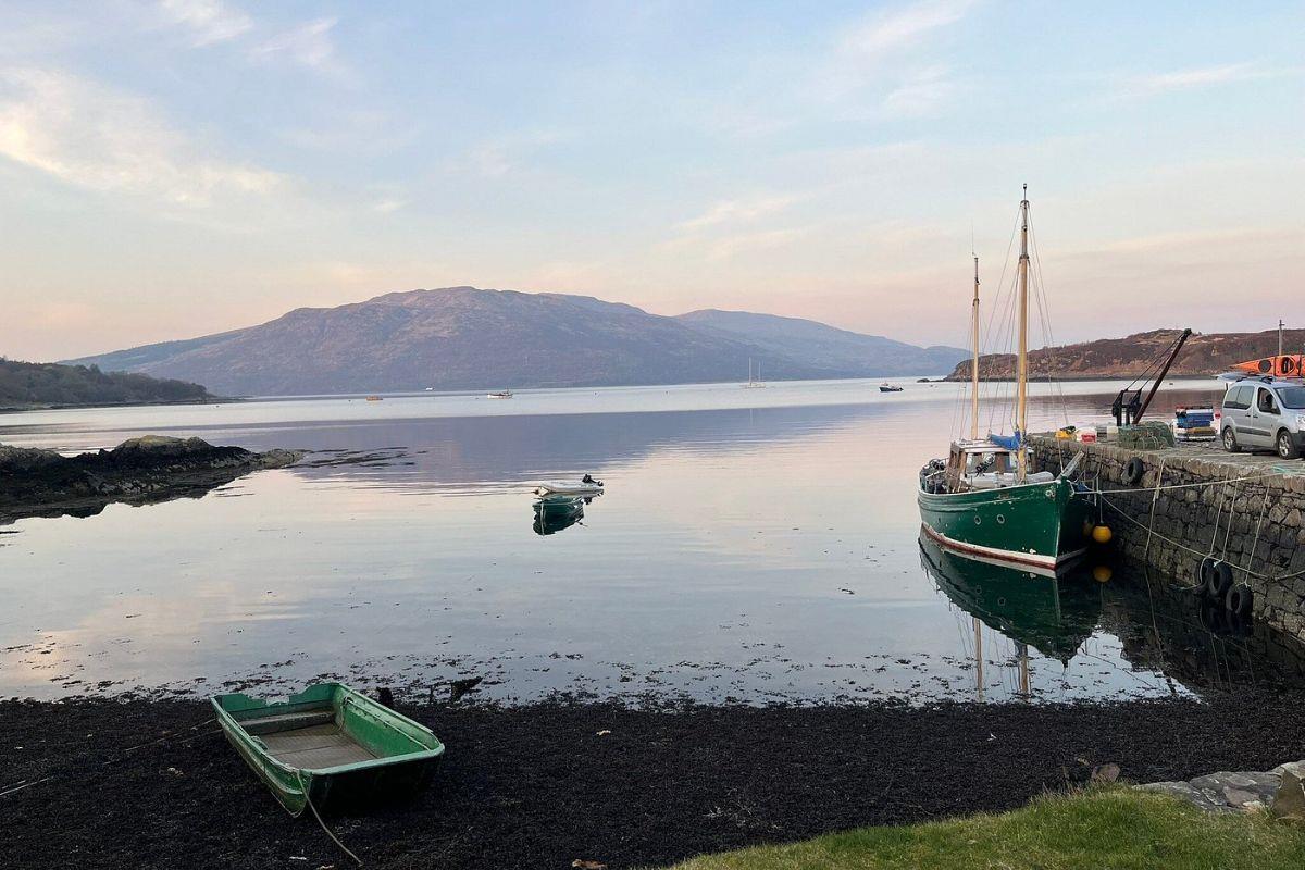 Boats moored in a Scottish loch harbour at sunrise