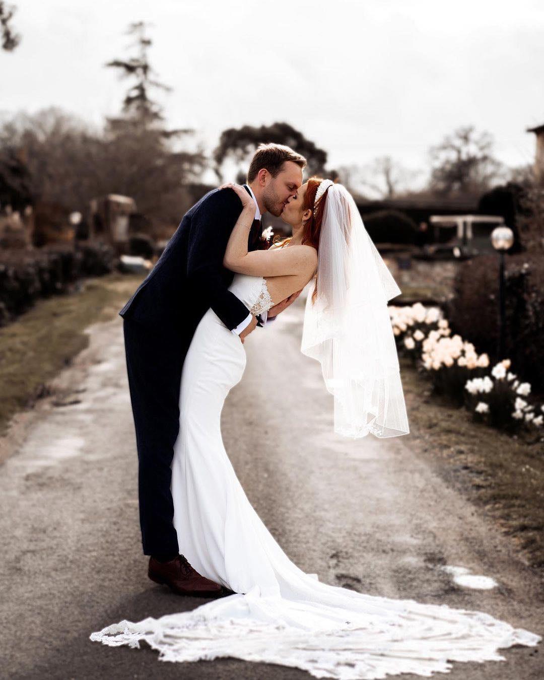 Bride and groom kissing on Widbrook Grange's driveway 