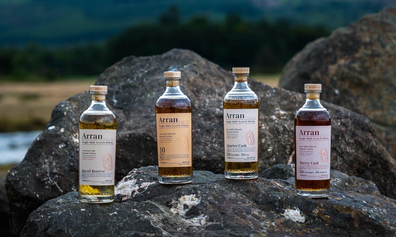 Four bottles of Arran Whisky lined up on rocks
