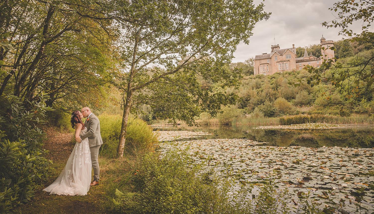 Couple with venue in background. Photo Credit: Duncan Ireland Photography