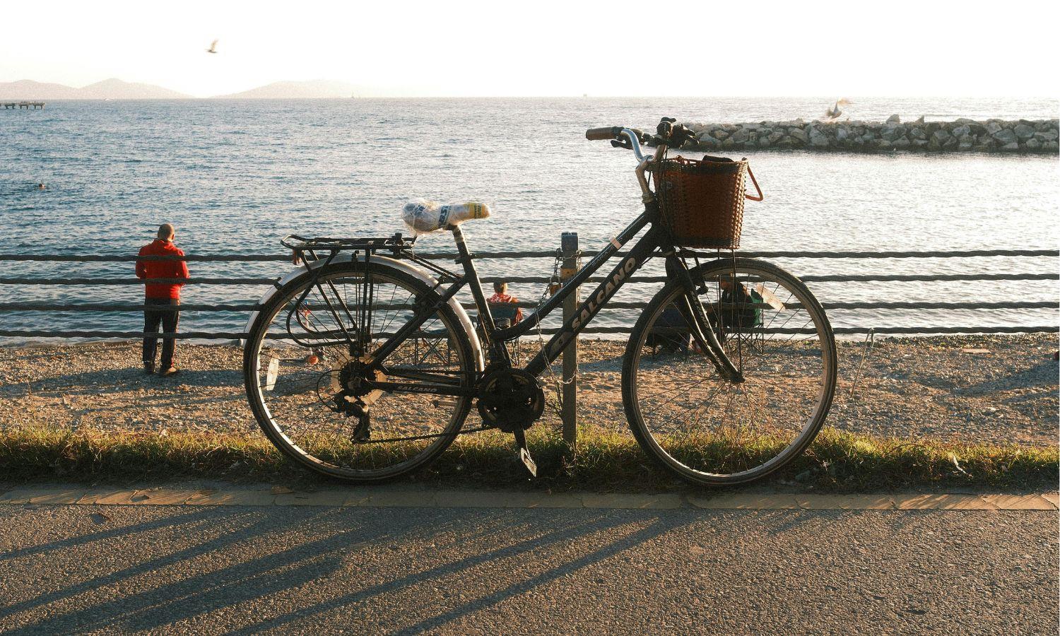 Bicycle chained to railings by beach