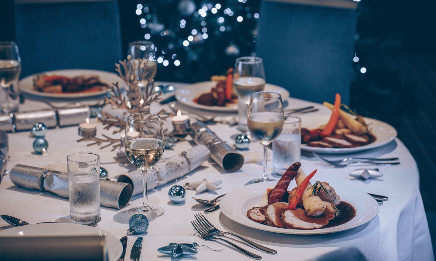 Christmas dinner on a decorated table with Christmas crackers and wine