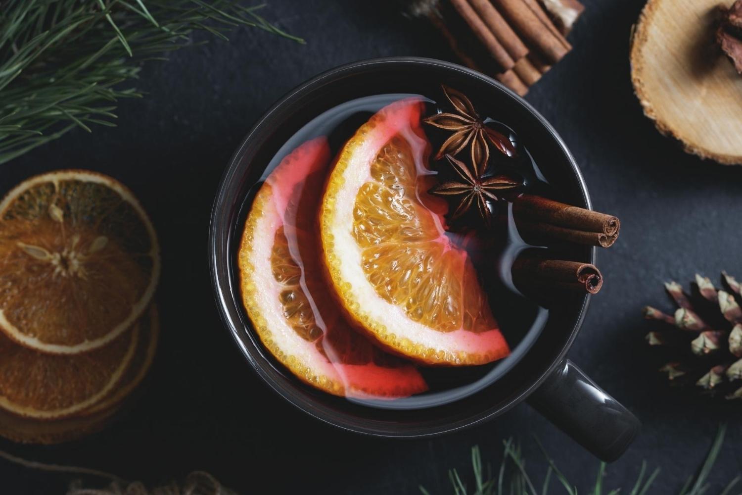 Close up of a glass of mulled wine garnished with oranges