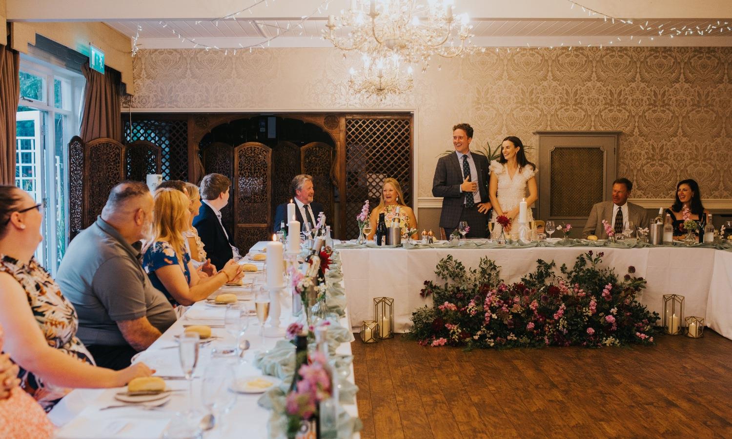 Events suite in a hotel dressed for a wedding with wedding guests dining