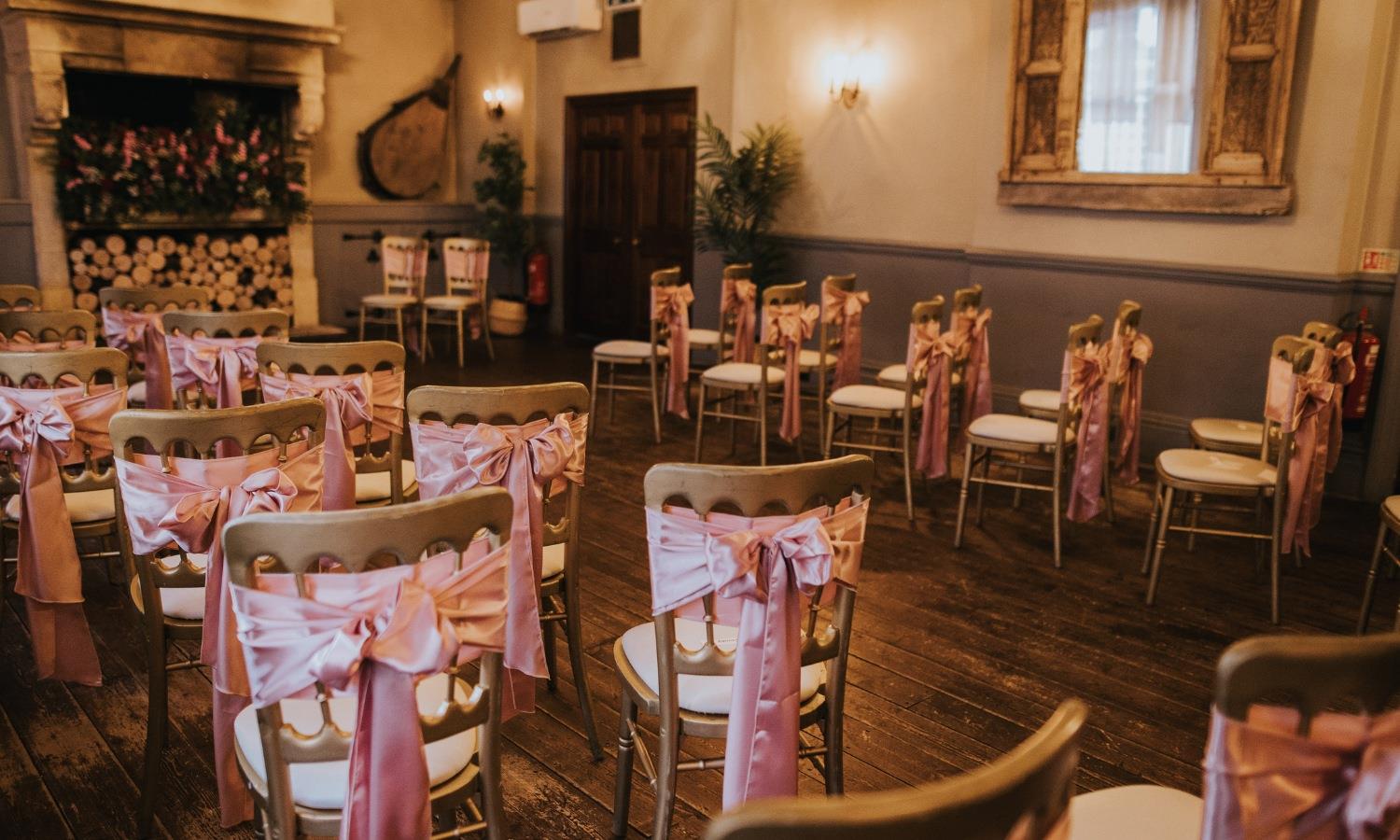 Rustic wedding venue ready for wedding ceremony with gold chairs
