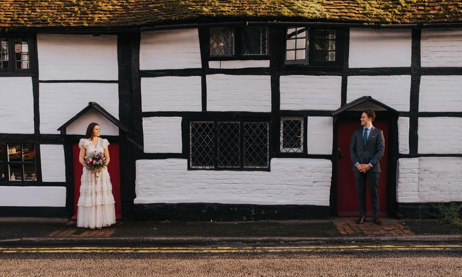 Wedding couple stood apart in separate doorways 