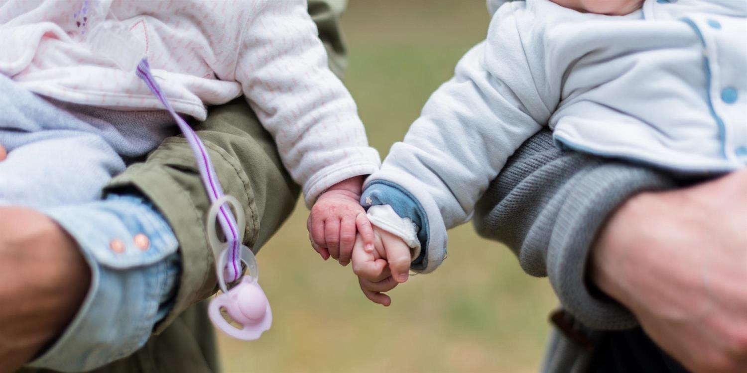 Two babies holding hands