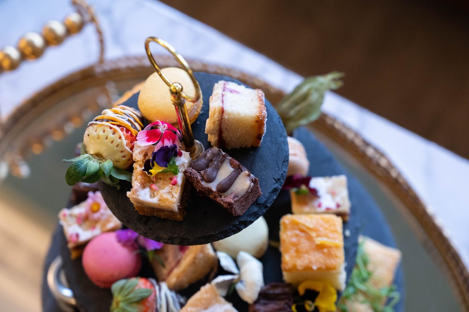 Close up of afternoon tea cakes and savoury bites on a cake stand