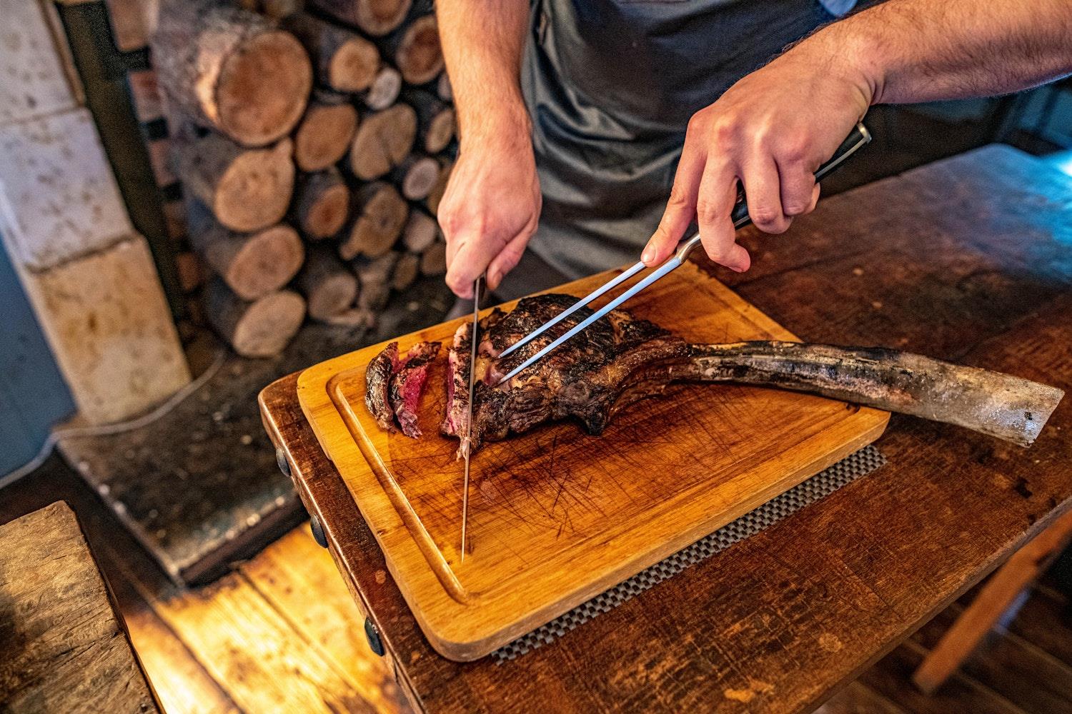 Chef carving a Tomahawk Steak at the Elephant Hotel