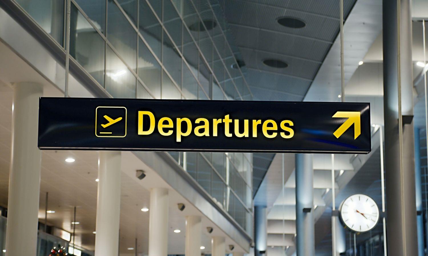 Airport departures sign directing passengers to the departure gates