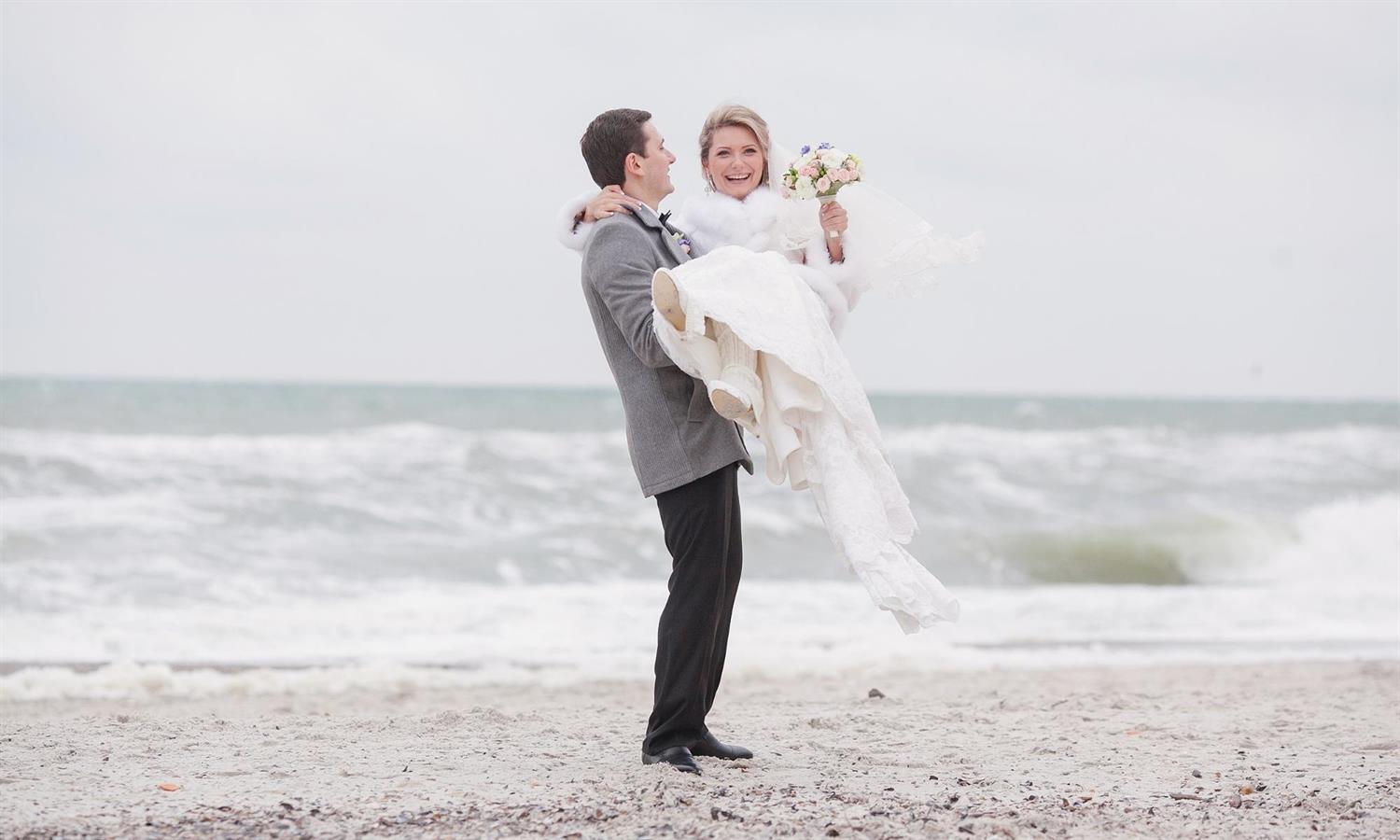 Wedding couple on the beach with bouquet