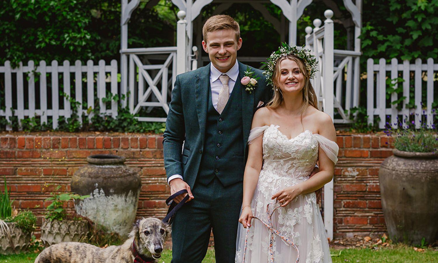 Wedding couple by gazebo with dog