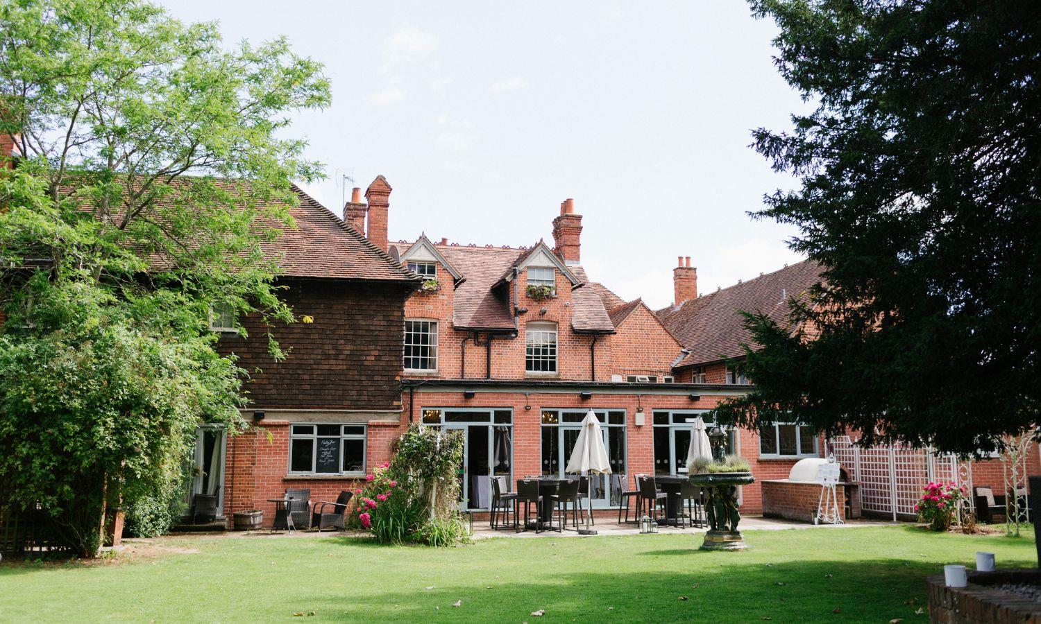 Rear of the Elephant Hotel with manicured gardens and seating