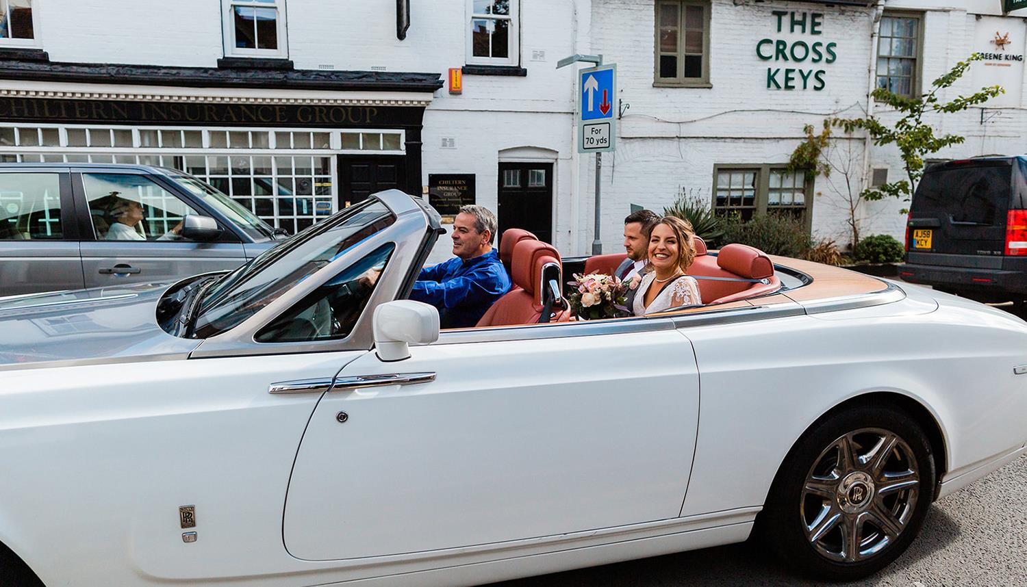 Wedding car with bride and groom sitting on rear seat. Photo Credit: Philip Quinnell