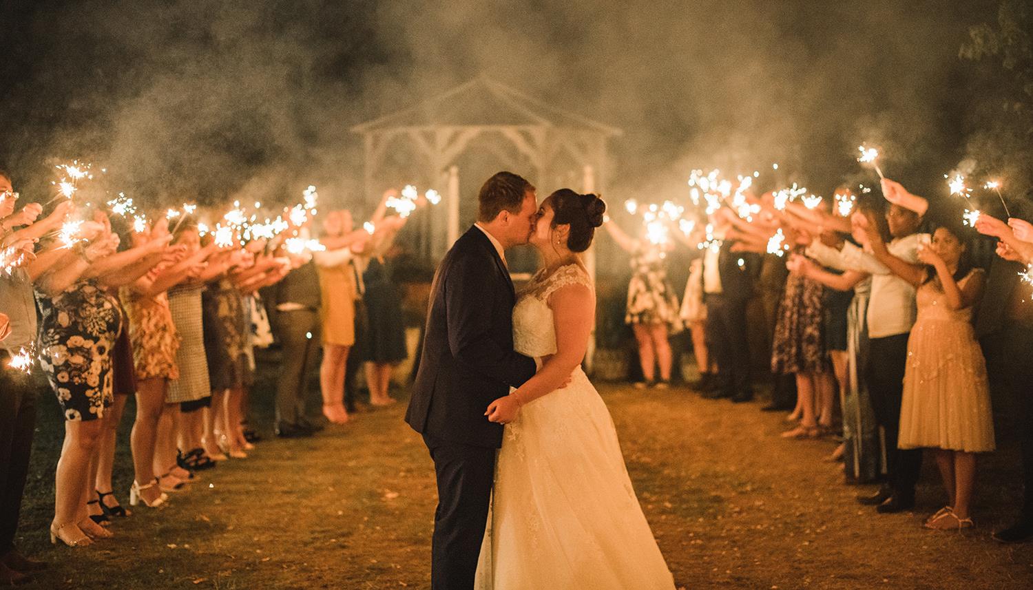 Bride & Groom kiss surrounded by sparklers in our private garden, of The Elephant wedding venue