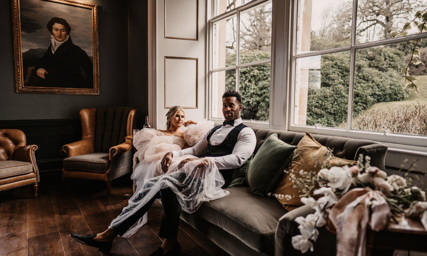 Newlywed couple sat in opulent sitting room at Auchen Castle