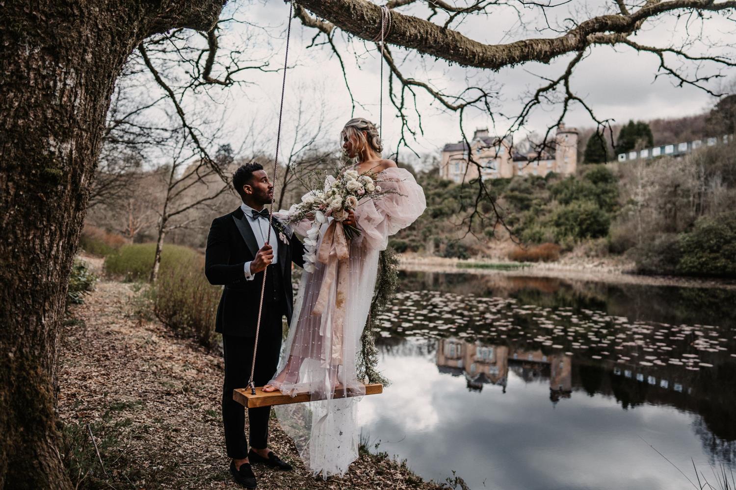 Wedding couple on a swing by the lake at Auchen Castle