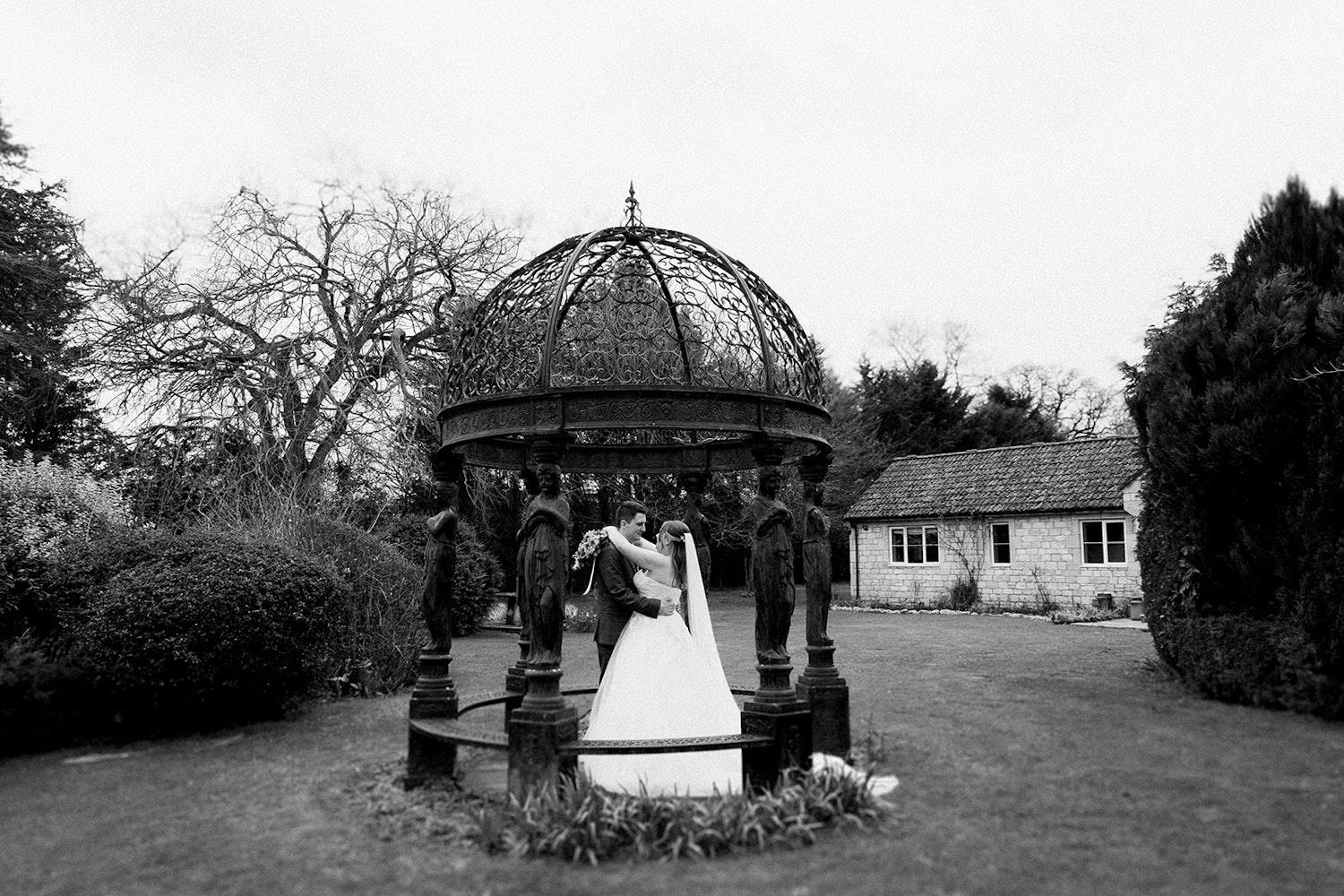 Black & white of couple embracing in gazebo (c) Ivy & Pine 