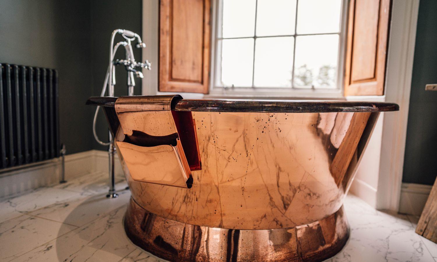 Copper bath in luxury hotel room with window