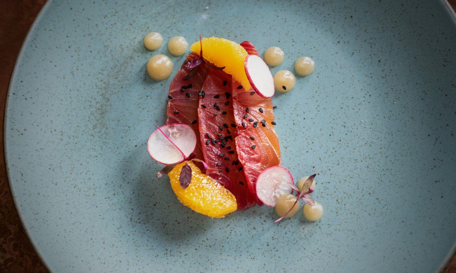 Pickled salmon served with radish and orange in fine dining style