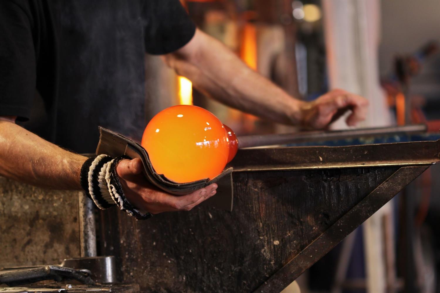 Artisan showing how glass is blown