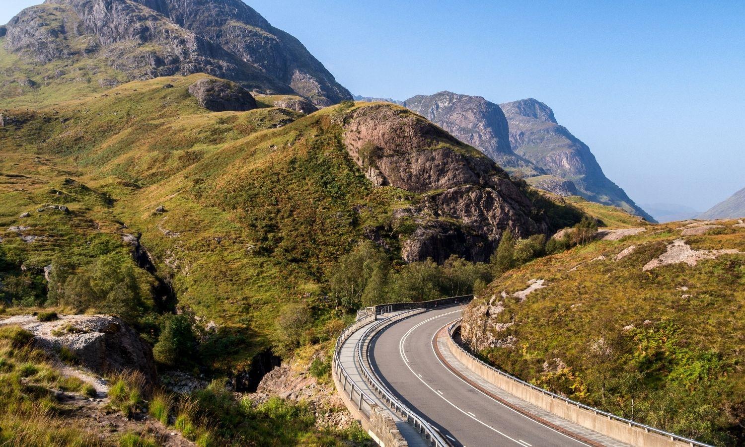 Scenic road winding through Glencoe in the Scottish Highlands, a popular driving route to Skye