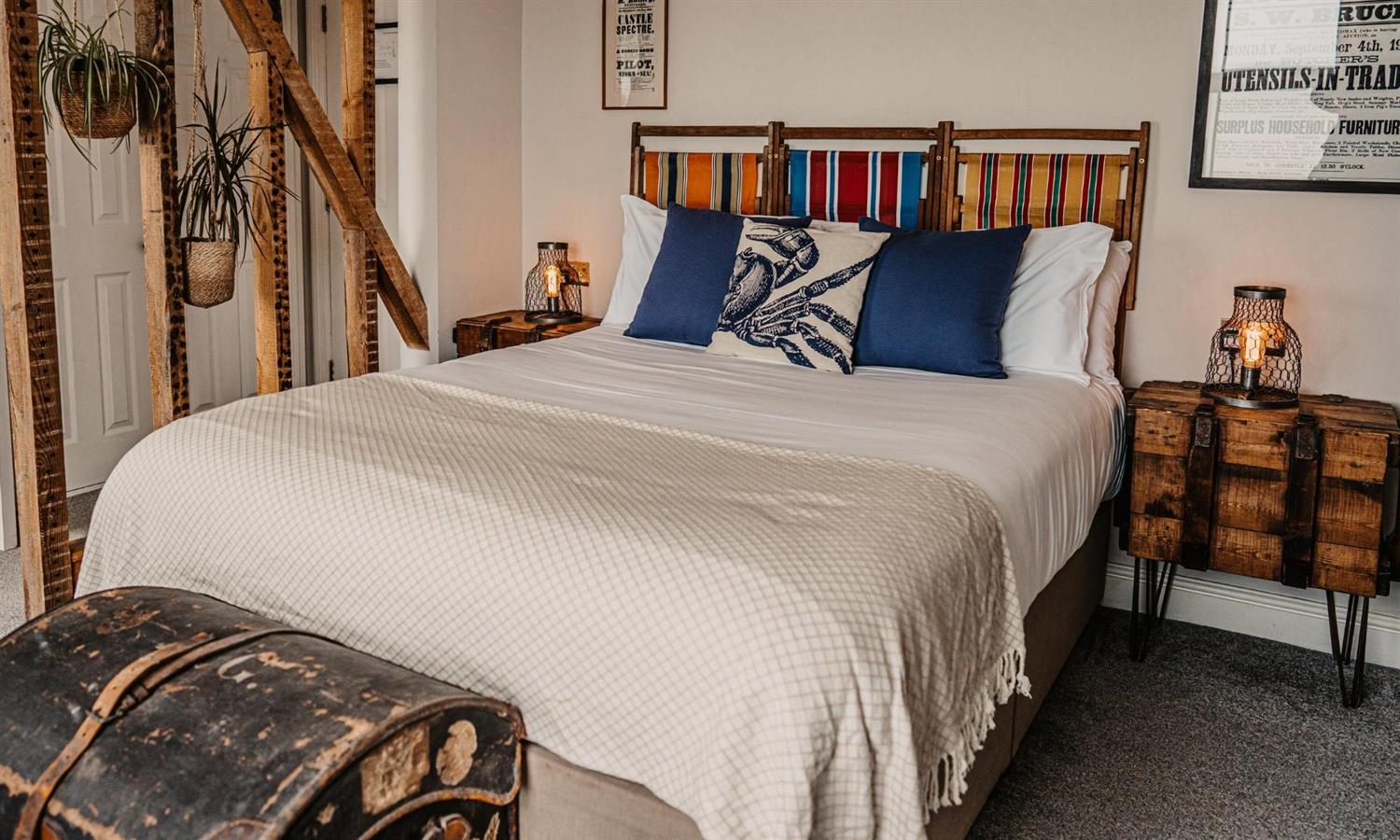 Hotel bed at The Ship Inn with cushions and chest