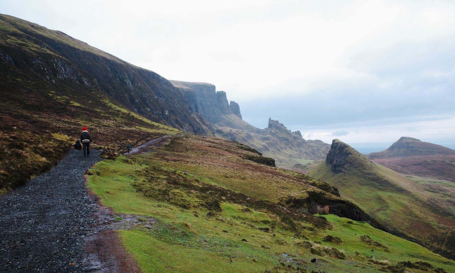 Walkers following a trail through the Quiraing on the Isle of Skye with dramatic rock formations
