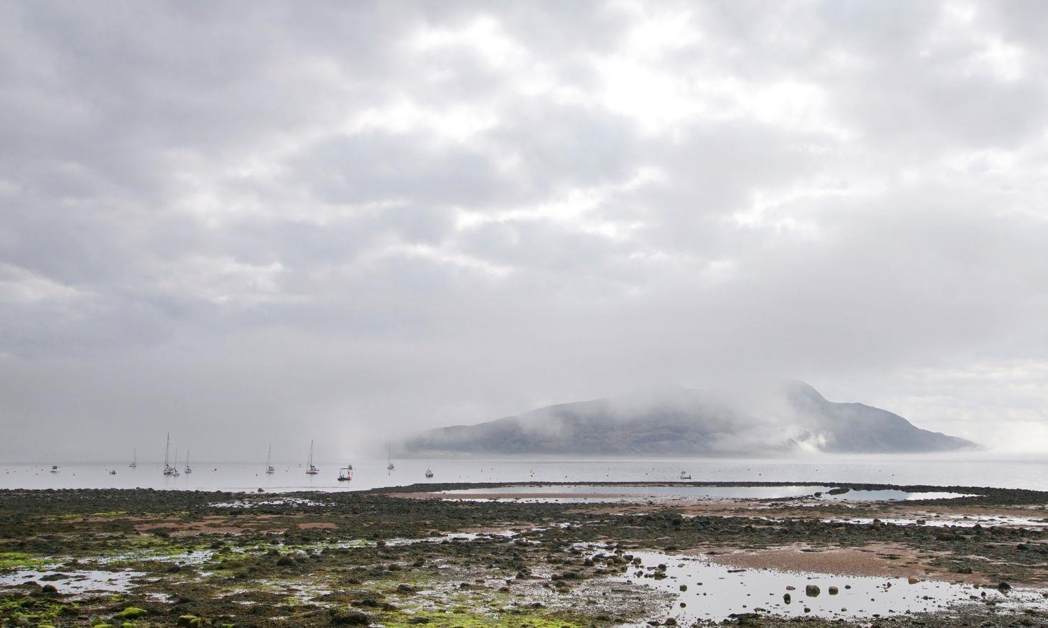 Holy Isle as viewed from Isle of Arran on a cloudy, misty day