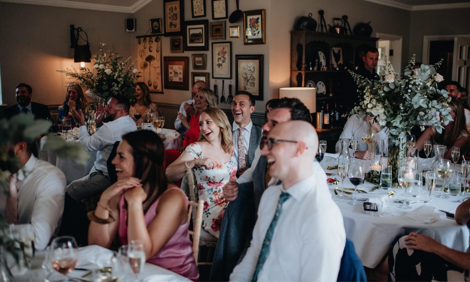 Wedding guests laughing at wedding speches